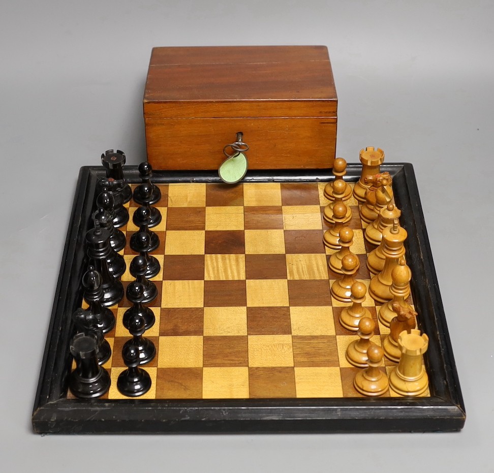 A late 19th / early 20th century weighted Staunton chess set, red crown stamps, kings 7.5cm, with inlaid chess board 32cm